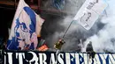 Aksi fans Napoli mengibarkan bendera saat mendukung timnya melawan Genoa pada lanjutan Serie A di Luigi Ferraris stadium, Genoa, (25/10/2017). Napoli menang 3–2. (AFP/Vincenzo Pinto)