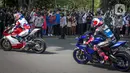 Antusias warga menyaksikan parade pembalap MotoGP di kawasan Jakarta, Rabu (16/3/2022).  Gelaran parade MotoGP di Jakarta dalam rangka penyambutan event MotoGP Mandalika 2022. (Liputan6.com/Faizal Fanani)