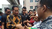 Presiden Joko Widodo membagikan sembako ke para tukang becak di Jalan Jendral Sudirman Palembang (Liputan6.com / Nefri Inge)