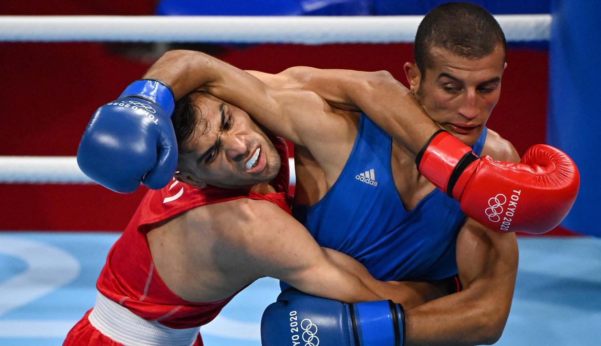 Petinju asal Iran, Daniyal Shahbakhsh (kiri) melawan petinju Maroko Mohamed Hamout dalam pertandingan tinju kelas bulu putra pada Olimpiade Tokyo 2020 di Kokugikan Arena, Tokyo, Sabtu (24/7/2021). (Foto: AFP/Luis Robayo)