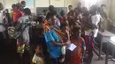 Sejumlah warga dan anak mereka antre mendapatkan pengobatan dan vaksin campak di Kabupaten Asmat, Papua, Jumat (19/1). Satgas Kesehatan TNI menyalurkan bantuan berupa vaksin ke kampung-kampung terpencil di Kabupaten Asmat. (LIputan6.com/Pool/Puspen TNI)