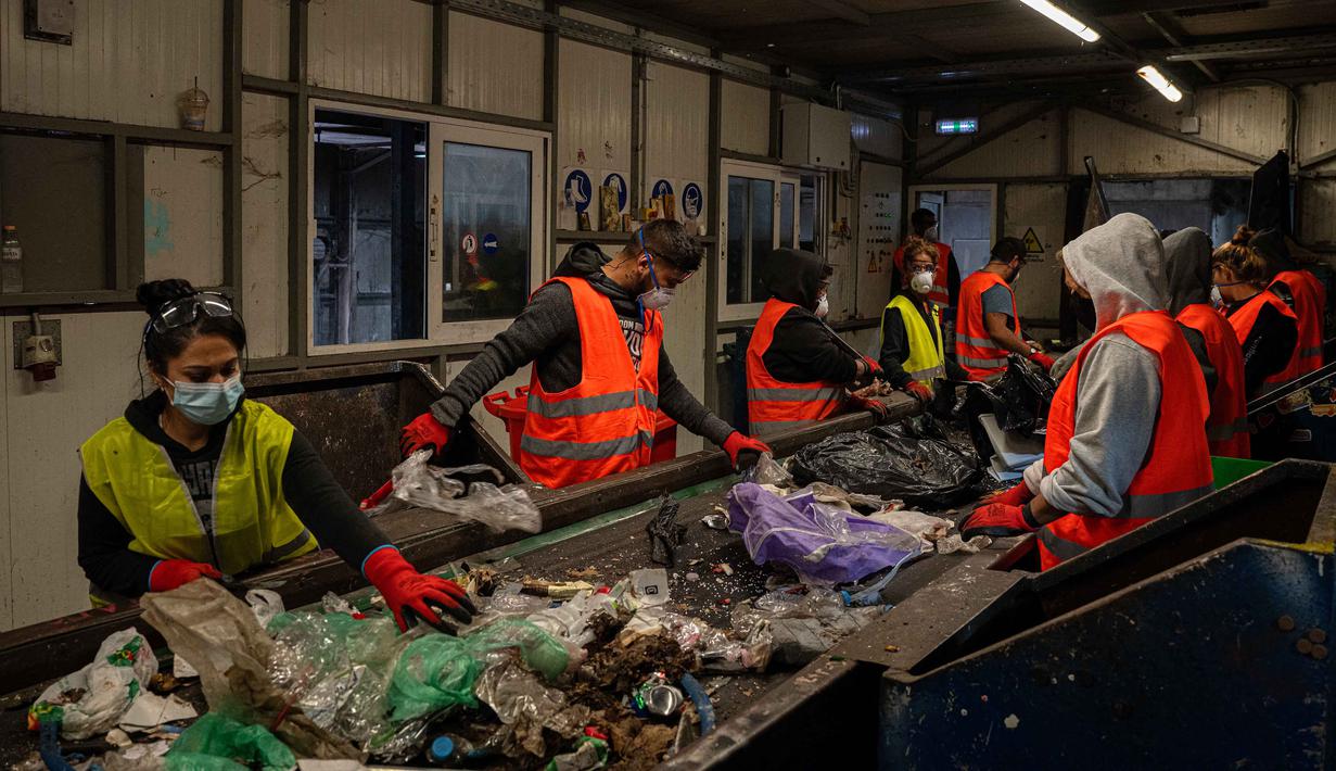 Untuk mengatasi hal tersebut, Pemerintah Kota North Corfu telah meluncurkan program yang mengharuskan warga memisahkan sampah mereka ke dalam lebih dari selusin tempat sampah. Tampak dalam foto, para pekerja memisahkan benda-benda plastik dari bahan limbah lainnya di atas conveyor belt di pabrik daur ulang di kota Corfu pada 15 Oktober 2025. (Angelos TZORTZINIS/AFP)