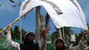 Dua guru membentangkan bendera saat unjuk rasa di depan Gedung DPR/MPR, Jakarta, Kamis (12/1). Mereka juga menuntut tunjangan sertifikasi bagi guru agama yang bernaung di Kemenag yang hingga kini belum terbayar. (Liputan6.com/Johan Tallo)