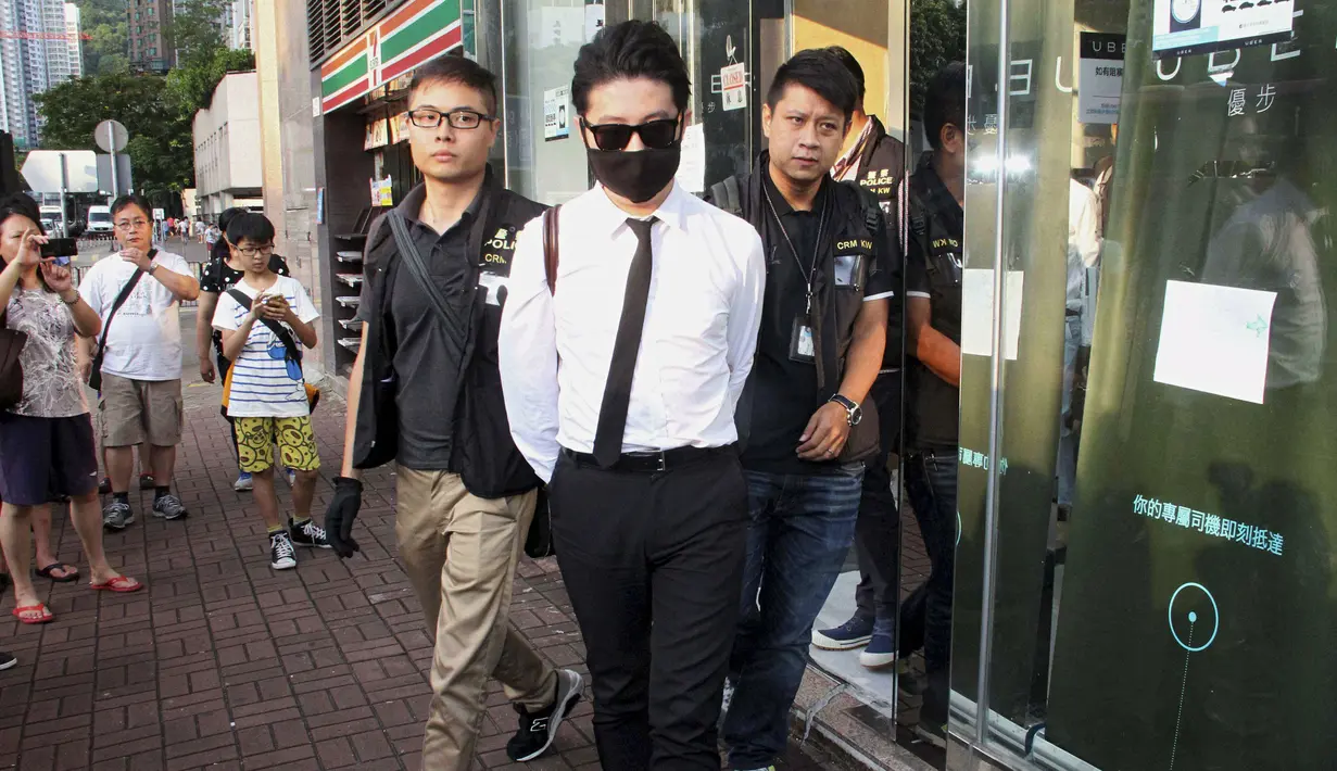 Polisi Hong Kong mengamankan seorang staff saat razia di kantor Uber Inc, Selasa (11/8/2015). Dalam razia ini polisi mengamankan 5 orang yang tertangkap basah memberikan jasa pelayanan sebagai sopir taxi dengan kendaraan ilegal. (REUTERS/Apple Daily)
