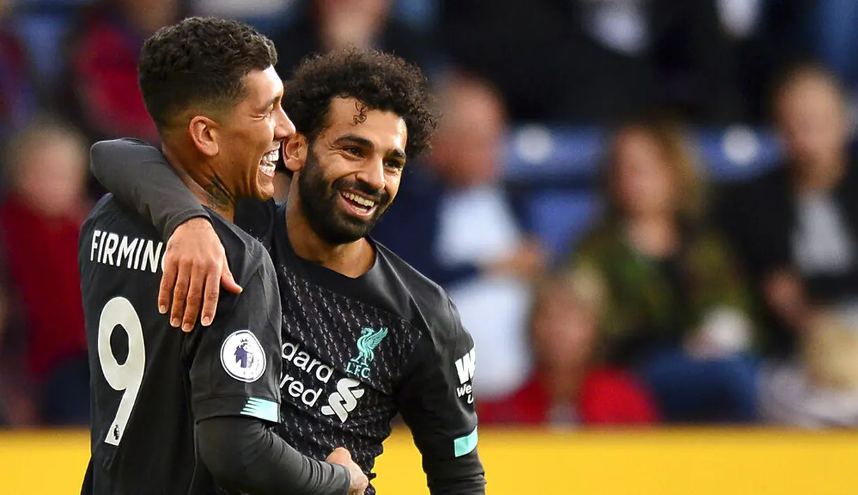 Striker Liverpool, Roberto Firmino, melakukan selebrasi bersama Mohamed Salah usai membobol gawang Burnley pada laga Premier League 2019 di Stadion Turf Moor, Sabtu (31/8). Liverpool menang 3-0 atas Burnley. (AP/Anthony Devlin)