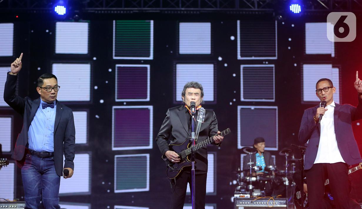 Penyanyi dangdut Rhoma Irama (tengah) tampil bersama Menteri Pariwisata dan Ekonomi Kreatif Sandiaga Uno (kanan) dan Gubernur Jawa Barat Ridwal Kamil (kiri) pada acara HUT ke-28 Indosiar di Studio 6 EMTEK City, Jakarta, Rabu (11/1/2023). Rhoma Irama membawakan lagu berjudul "Butter" dari BTS dan duet bareng Sandiaga Uno serta Ridwan Kamil saat membawakan lagu berjudul "275 Juta". (Fimela.com/Bambang E. Ros)