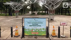 Pengumuman penutupan sementara Taman Lapangan Banteng terlihat di Jakarta, Minggu (20/9/2020). Seluruh taman kota dan hutan kota ditutup kembali untuk sementara terkait pemberlakuan PSBB total di Jakarta guna menekan penyebaran virus covid-19. (Liputan6.com/Immanuel Antonius)