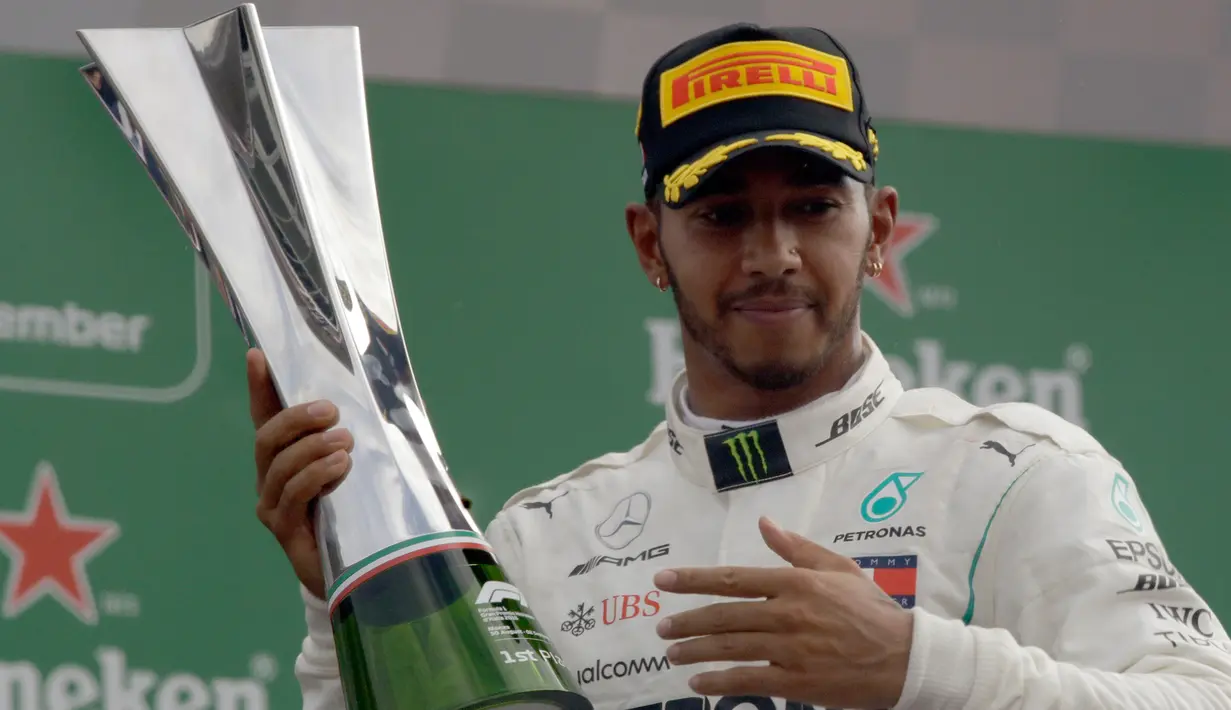 Pembalap Mercedes, Lewis Hamilton berpose dengan trofi usai meraih kemenangan GP Italia di Sirkuit Monza di Monza, (2/9). Hamilton berhasil menang di GP Italia 2018 dengan catatan waktu terbaik 1 jam 16 menit 54,484 detik. (AP Photo/Luca Bruno)