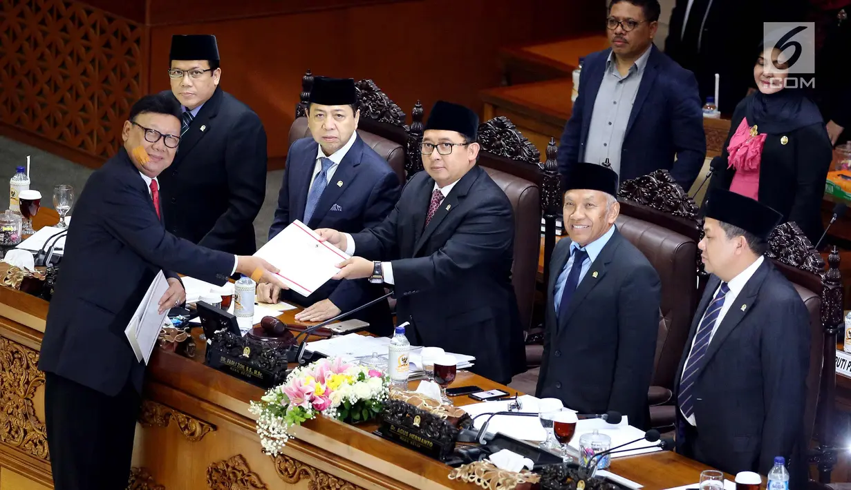 Mendagri, Tjahjo Kumolo menyerahkan dokumen pandangan Akhir Pemerintah kepada Ketua Sidang Paripurna Fadli Zon saat sidang paripurna ke-9 di gedung Parlemen, Senayan, Jakarta, Selasa (24/10). (Liputan6.com/Johan Tallo)