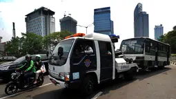 Petugas Dinas Perhubungan (Dishub) DKI Jakarta menderek bus Kopaja yang ngetem di kawasan Stasiun Sudirman, Jakarta (17/7). Razia ini digelar untuk menyambut Asian Games Agustus mendatang. (Merdeka.com/Arie Basuki)