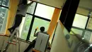 Para petugas sibuk menyelesaikan pekerjaannya membersihkan jendela ruang sidang yang akan digunakan oleh Boediono, Kamis (8/5/14). (Liputan6.com/Faisal R Syam)