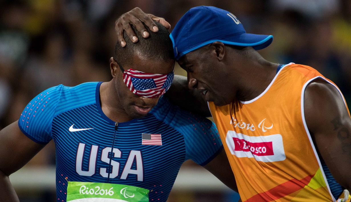 Atlet AS, David Brown (kiri) merayakan medali emas bersama pemandunya, Avery Jerome cabang lari 100m - T11 Final putra di Olympic Stadium, pada ajang Paralimpik Games 2016, Rio de Janeiro, Brasil,(10/9/2016. (AFP/OIS/IOC/Thomas Lovelock for OIS/IOC)