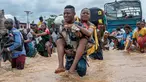 Warga menggendong seorang perempuan sementara lainnya menyeberangi banjir di distrik Ndjili, Kinshasa, pada 6 April 2025. (Hardy BOPE/AFP)
