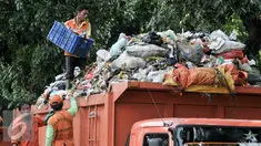 Pekerja Sudin Kebersihan Jagakarsa mengangut sampah dari mobil bak di TPS sementara, Jakarta, Senin (11/7). Pasca libur Lebaran, volume sampah di Kecamatan Jagakarsa diperkirakan mencapai 200 ton. (Liputan6.com/Yoppy Renato)