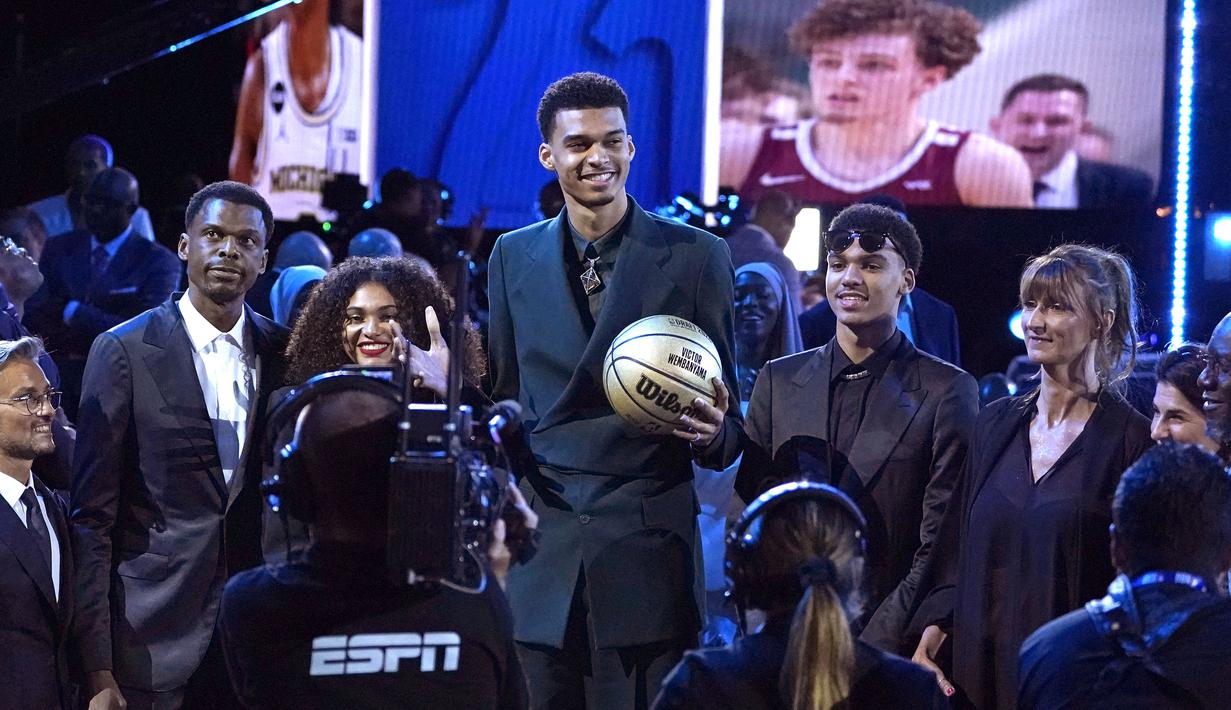 Pebasket Prancis, Victor Wembanyama (tengah) berpose dengan ayahnya, Felix (kiri), seaudara peremupannya, Eve (kedua kiri), saudara laki-lakinya, Oscar (kedua dari kanan), dan Ibunya, Elodie de Fautereau (kanan) sebelum saat menjadi pilihan pertama oleh San Antonio Spurs di NBA Draft 2023 di Barclays Center, New York city, 23 Juni 2023 WIB. (AFP/Timothy A. Clary)