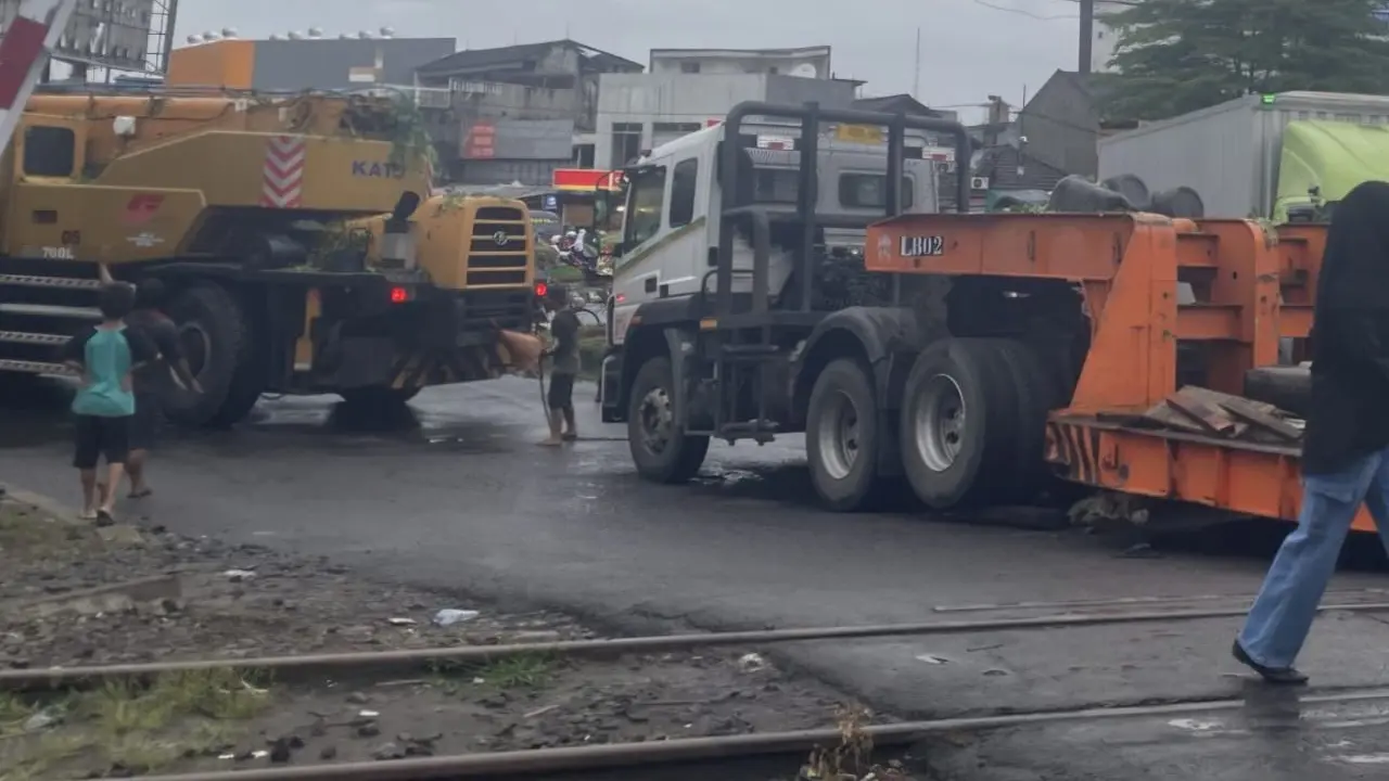 Crane nyangkut di rel KRL.