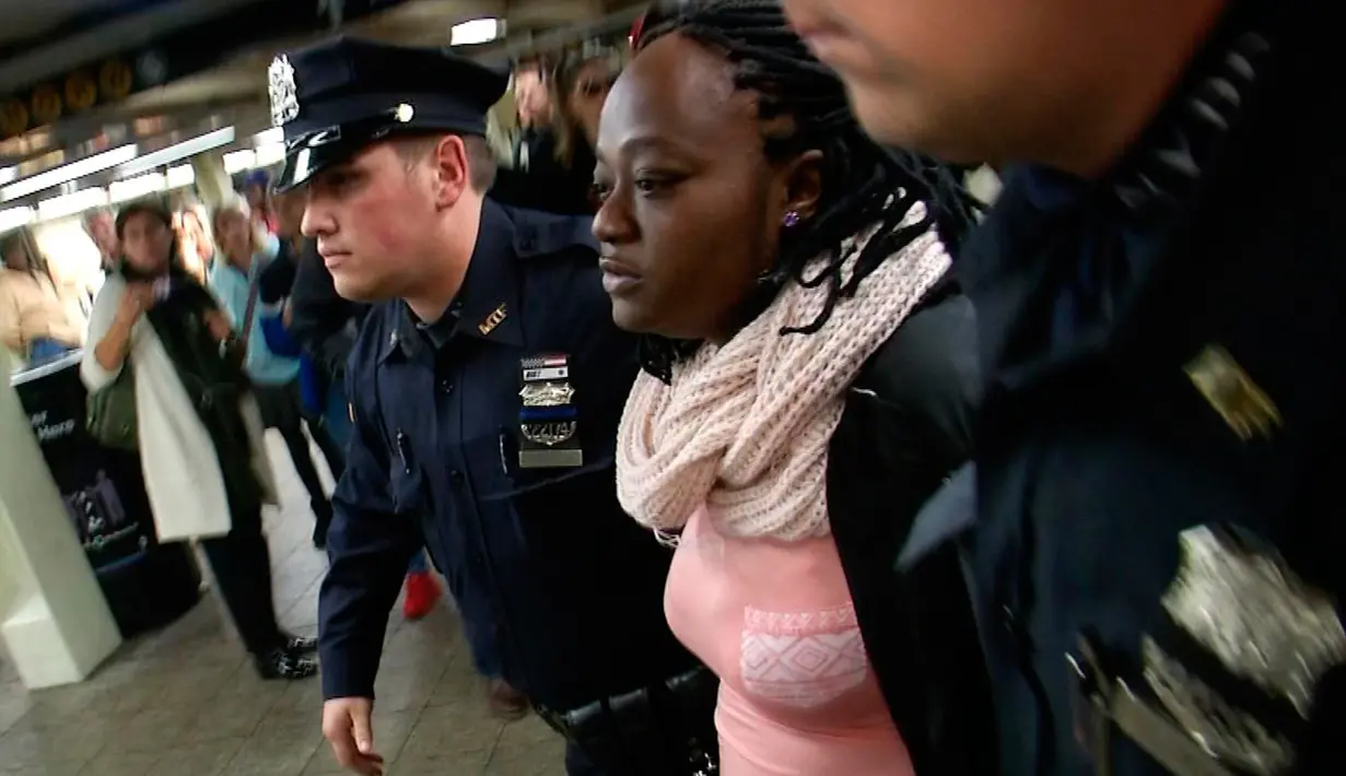 Seorang perempuan tersangka pelaku pendorongan ditangkap petugas NYPD pendorongan di stasiun Time Square, New York, Senin (7/11). Tersangka diidentifikasi sebagai Melanie Liverpool-Turner namun motifnya belum diketahui. (REUTERS/James Carman)