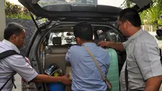 Petugas KPK menurunkan sejumlah barang hasil penggeledahan rumah  mantan Gubernur Papua Barnabas Suebu dari dalam mobil, Jakarta, (22/10/14). (Liputan6.com/Miftahul Hayat)
