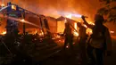 Petugas pemadam kebakaran berjuang memadamkan kobaran api di sebuah rumah di Malibu, California, AS, Jumat (9/11). Api Woolsey pertama kali dilaporkan terdeteksi dekat Thousand Oaks. (AP Photo/Ringo H.W. Chiu)