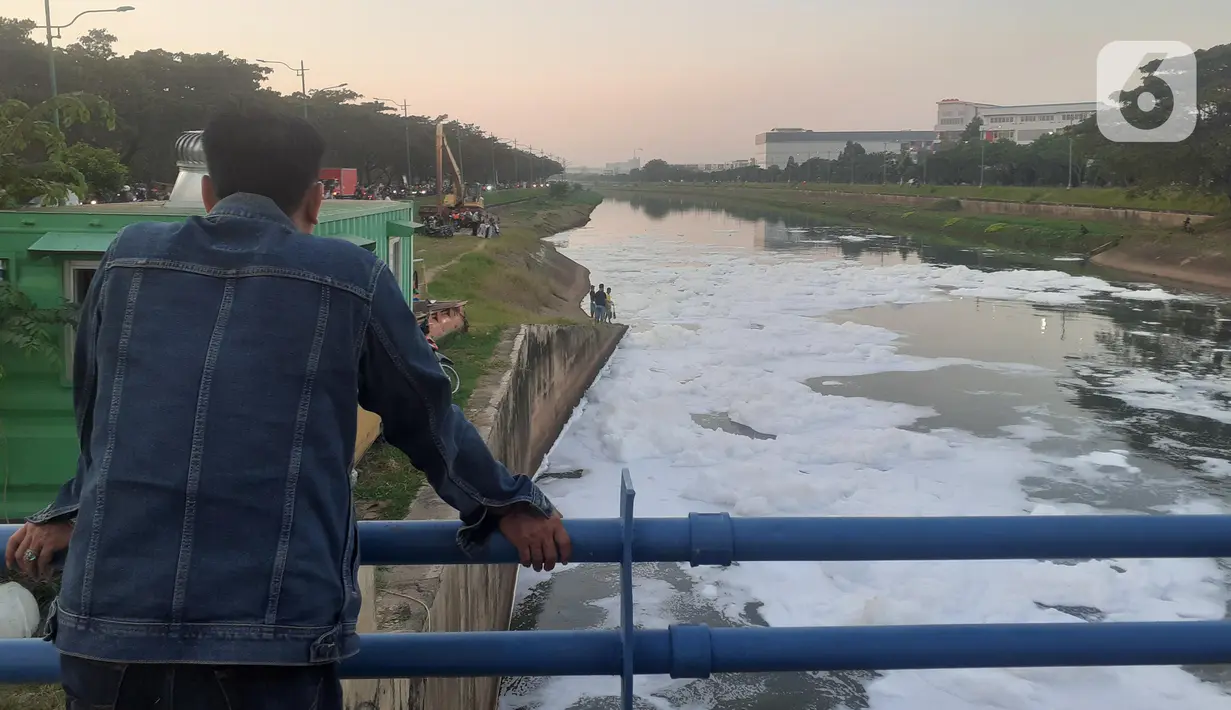 Warga melihat limbah busa di Pintu Air WFIR 2 Ujung Menteng, Cakung, Jakarta, Minggu (5/7/2020). Kondisi ini sudah terjadi selama lebih kurang satu pekan. (Liputan6.com/Helmi Fithriansyah)
