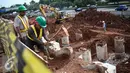 Pekerja mencangkul tanah di proyek pembangunan jalur LRT seksi Cawang-Cibubur, Jakarta, Kamis (8/12). Jalur LRT ini nantinya akan digunakan sebagai salah satu transportasi dalam pelaksanaan Asian Games 2018 .(Liputan6.com/Faizal Fanani)