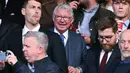Pelatih legendaris Setan Merah, Sir Alex Ferguson, tampak tersenyum melihat Manchester United sukses melaju ke final Liga Europa 2024/2025 usai mengandaskan Athletic Bilbao dalam laga leg kedua semifinal yang dihelat di Old Trafford, Jumat (9/5/2025) dini hari WIB. (AFP/Oli Scarff)