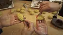<p>Perempuan Palestina membuat kue tradisional berisi kurma dan kacang-kacangan dalam persiapan untuk liburan Idul Fitri, di kota Hebron, Tepi Barat, pada 28 April 2022. Seluruh umat Muslim di dunia akan menandai berakhirnya bulan suci Ramadhan dengan Idul Fitri. (HAZEM BADER / AFP)</p>