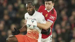 Bek Manchester United atau MU Harry Maguire berebut bola dengan penyerang West Ham Michail Antonio pada putaran kelima Piala FA di Old Trafford, Kamis (2/3/2023) dinihari WIB. MU yang sempat tertinggal mampu membalas lewat tiga gol. Semua gol lahir pada babak kedua. (AP Photo/Dave Thompson)