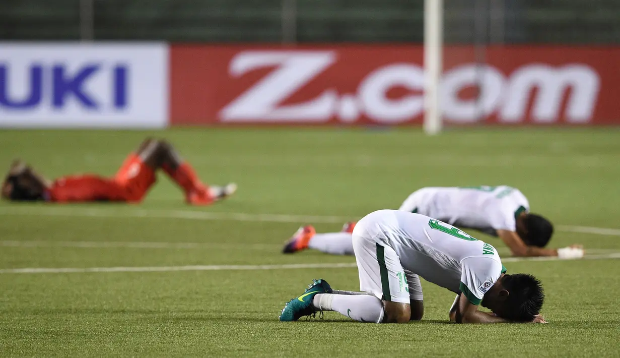 Para pemain Indonesia melakukan sujud syukur usai mengalahkan Singapura di laga hidup babak penyisihan grup di Piala AFF 2016, Manila, Jumat (25/11). Andik dan Stefano menjadi pahlawan kemenangan Indonesia atas Singapura. (AFP PHOTO / Ted Aljibe)
