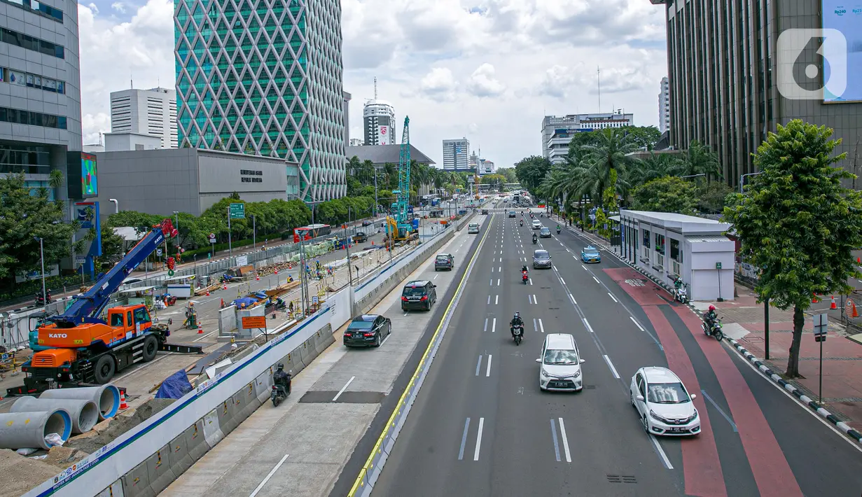 Sejumlah kendaraan melintas disamping proyek pembangunan MRT fase dua di Jalan MH Thamrin, Jakarta, Senin (22/3/2021). Rekayasa lalu lintas tersebut bertujuan untuk kelancaran pengerjaan proyek dan keselamatan serta keamanan bagi pengguna jalan di lokasi tersebut. (Liputan6.com/Faizal Fanani)