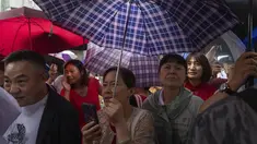Kerabat dan guru siswa yang mengikuti ujian masuk perguruan tinggi nasional tahunan yang juga dikenal sebagai "Gaokao" menunggu sesi pagi selesai saat hujan turun di Beijing, China, Jumat (7/6/2024). (AP Photo/Ng Han Guan)