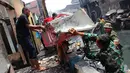 Sejumlah Petugas TNI dan Warga mengangkut puing sisa kebakaran di Kawasan kebon Melati Tanah Abang, Jakarta, Jumat (6/3/2015). Kebakaran yang terjadi menyebabkan setidaknya2 RW dan 6 RT di kelurahan kebon melati terbakar. (Liputan6.com/Helmi Afandi)