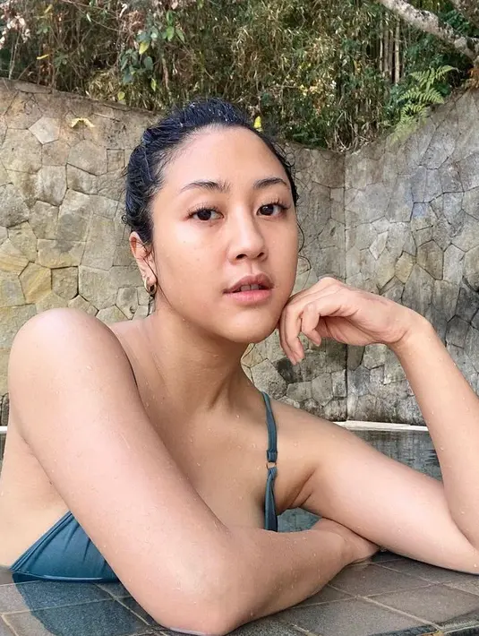 Sherina pun kembali mengambil potret dirinya dengan wajah tanpa makeup setelah berenang. Mengenakan bikini biru dengan rambut yang diikat cepol. [@sherinamunaf]