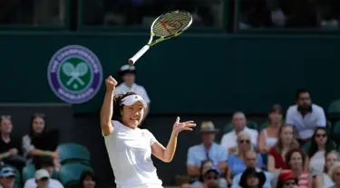 Petenis asal Jepang, Kurumi Nara kehilangan kendali atas raketnya setelah mengembalikan bola pukulan Petenis Rumania Simona Halep saat bertanding pada hari kedua tunggal putri Kejuaraan Tenis Wimbledon di London, (3/7). (AP Photo / Ben Curtis)