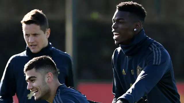 Pemain Manchester United, Paul Pogba, tertawa saat latihan jelang laga 16 besar Liga Champions. (AFP/Franck Fife)
