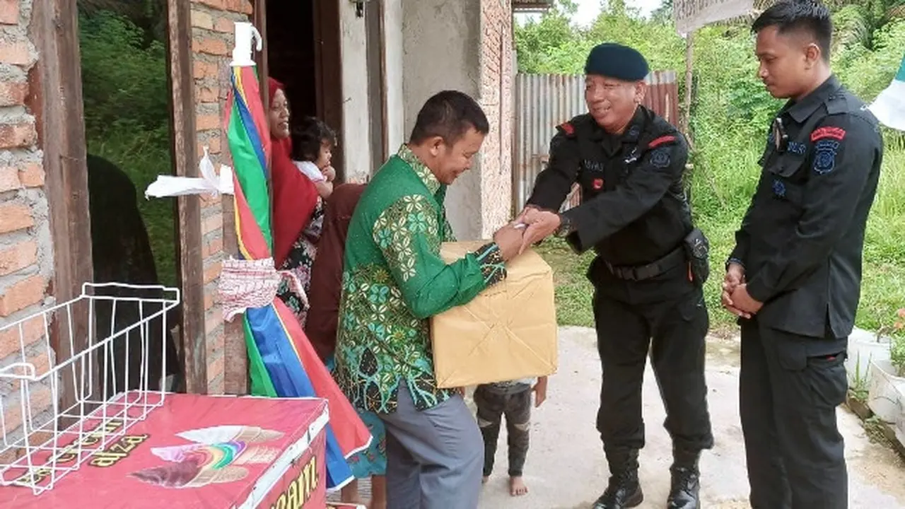 Personel Brimob Polda Riau menyerahkan bantuan kepada guru honorer dalam peringatan Hari Guru Nasional.