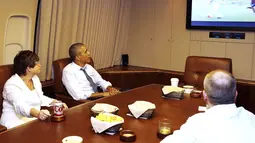 Bersama penasihat senior kepresidenan, Valerie Jarrett (kiri), orang nomor satu di Amerika Serikat, Barrack Obama menyaksikan laga Sam's Army melawan Der Panzer di atas pesawat Air Force One, (26//6/2014). (REUTERS/Larry Downing)
