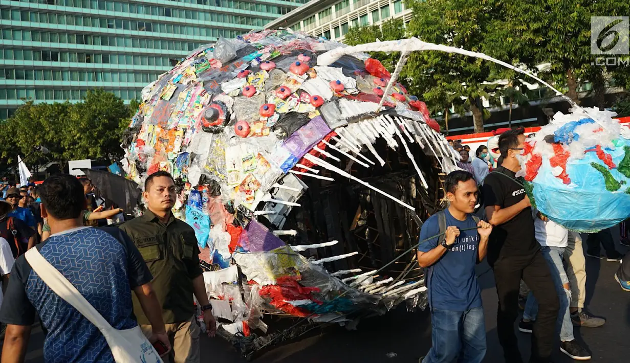 Sejumlah aktivis lingkungan mengarak monster plastik saat pawai 'Bebas Plastik' di kawasan MH Thamrin menuju Taman Aspirasi Monas, Jakarta, Minggu (21/7/2019). Pawai ditujukan sebagai kampanye tentang bahaya kantong plastik bagi ekosistem baik di laut maupun di darat (Liputan6.com/Immanuel Antonius)