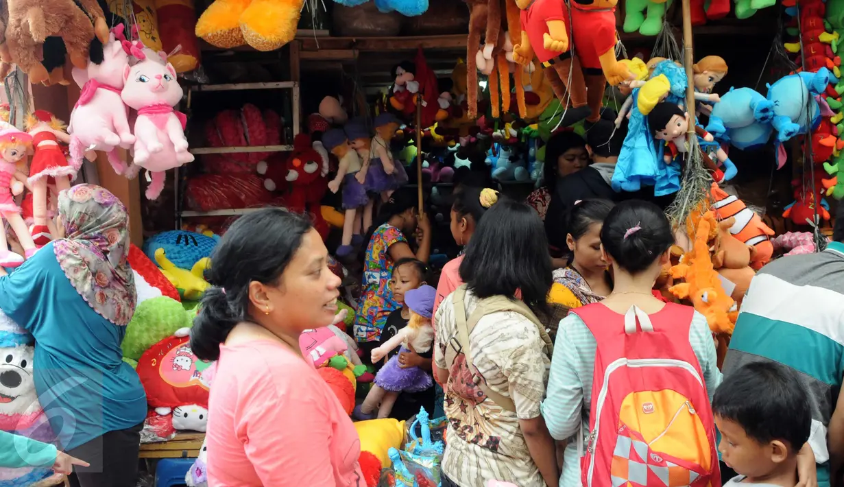 Pengunjung melihat boneka yang dijajakan oleh para pedagang di Ragunan, Jakarta, Minggu (27/12/2015). Pedagang mengaku omset penjualan pada Libur Natal kali ini melonjak 3x lipat dari pada biasanya. (Liputan6.com/Helmi Afandi)