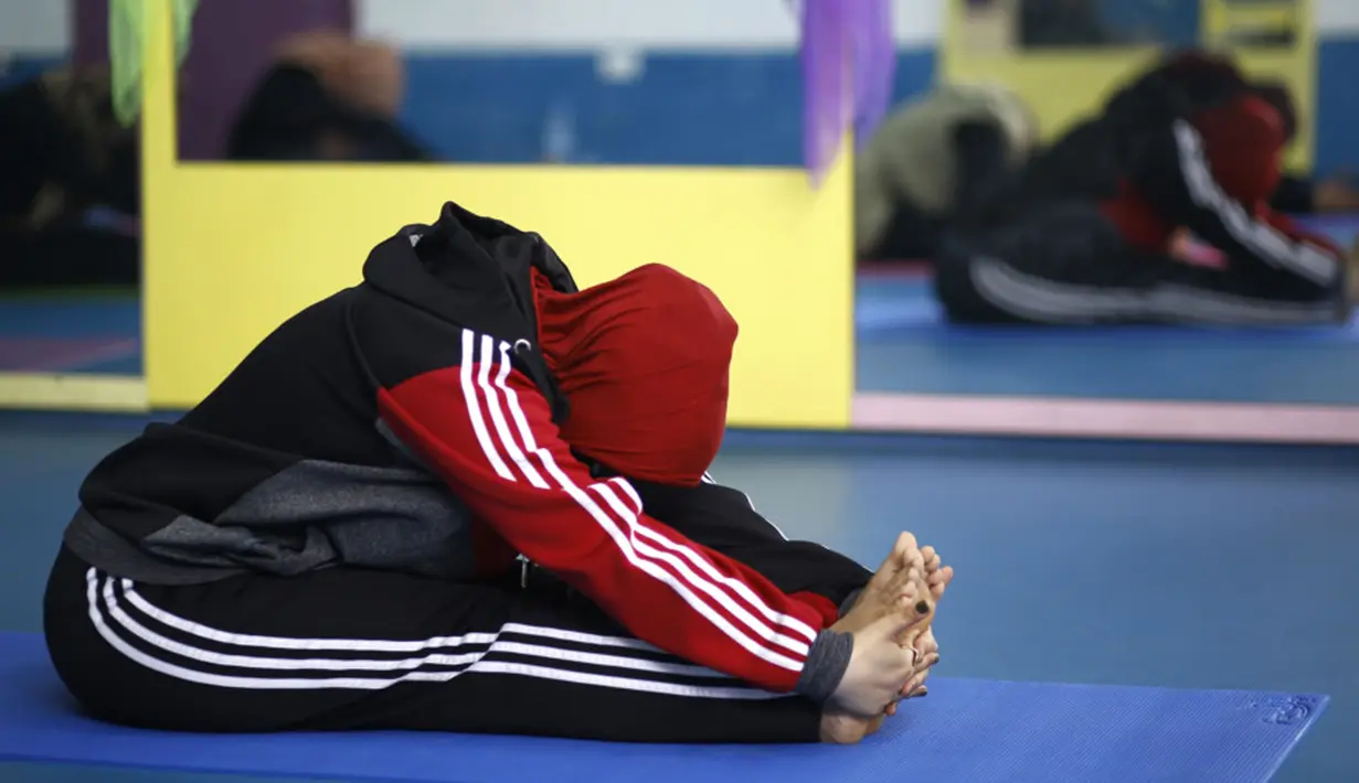 Seorang wanita Palestina melakukan sesi latihan yoga di pusat pelatihan yoga wanita pertama di kota Gaza, 28 Maret 2018. Kelas yoga dengan menggunakan pusat kebugaran darurat ini bertujuan  melatih 32 perempuan sebagai pelatih Yoga. (MOHAMMED ABED/AFP)