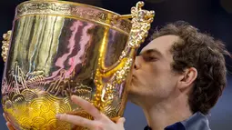 Petenis Inggris Raya, Andy Murray mencium trofi sebagai juara turnamen China Open setelah mengalahkan petenis Bulgaria Grigor Dimitrov, di Beijing, Minggu (9/10). Titel tersebut diraih usai melakoni duel selama satu jam 57 menit. (NICOLAS ASFOURI/AFP)