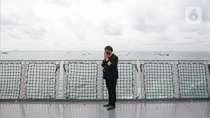 Seorang pilot berdoa saat prosesi tabur bunga di lokasi jatuhnya pesawat Sriwijaya Air SJ 182 di perairan Kepulauan Seribu, Jumat (22/1/2020). Sebanyak 50 orang perwakilan keluarga melakukan tabur bunga sebagai penghormatan terakhir kepada para korban kecelakaan pesawat. (Liputan6.com/Faizal Fanani)