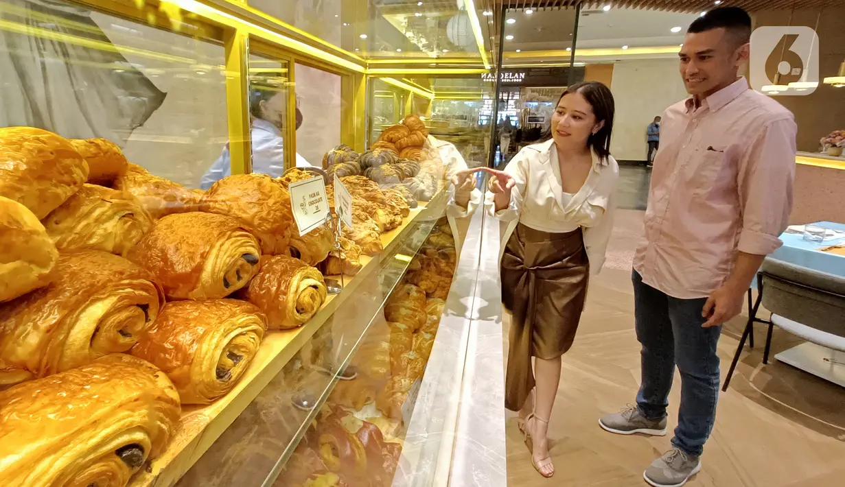 Marketing Manager Restoran La Verre Patisserie Raditya Pratama dan artis Prilly Latuconsina memilih roti di sela-sela pembukaan Restoran La Verre Patisserie di PIM 1 Jakarta, Senin (21/3/2022). Restoran bergaya fancy dan classy mengusung kosep Asian Fusion French Cafe. (Liputan6.com/Fery Pradolo)