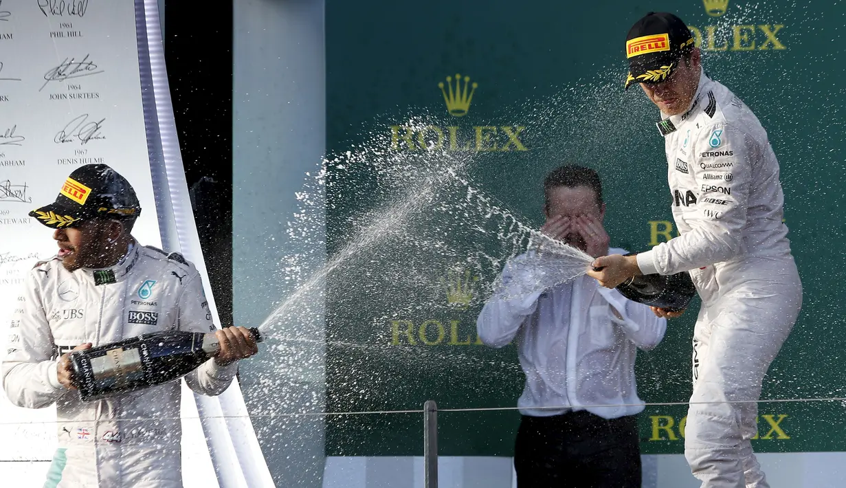 Nico Rosberg (kanan) dan Lewis Hamilton merayakan kemenangan perdana di seri pertama musim balap 2016 di Australia, Minggu (20/3/2016). Balapan perdana ini diwarnai tabrakan antara Fernando Alonso dan Esteban Gutierrez (Reuters/Brandon Malone)