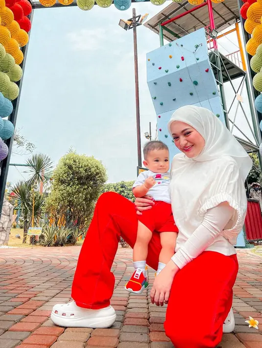 Artis Nathalie Holscher tampil kompak bersama Adzam dengan gaya kasual mengenakan kaos putih dipadukan dengan celana warna merah. (Instagram/nathalieholscher).