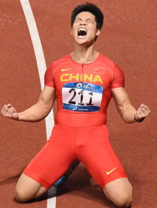 Pelari China, Su Bingtian berselebrasi seusai menjadi yang tercepat dalam final lari 100m putra Asian Games ke-18 di Stadion Utama Gelora Bung Karno,, Jakarta, Minggu (26/8). Su Bingtian meraih emas dengan catatan waktu 9,92 detik. (AFP/Anthony WALLACE)