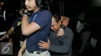 Petugas membawa Harry Ray Sanjaya saat KPK dan Polda Metro Jaya menggelar konferensi pers di KPK, Jakarta, Jumat (22/7). Harry ditangkap karena mengaku sebagai anggota KPK dan telah menipu seorang anggota DPRD Medan. (Liputan6.com/Helmi Afandi)