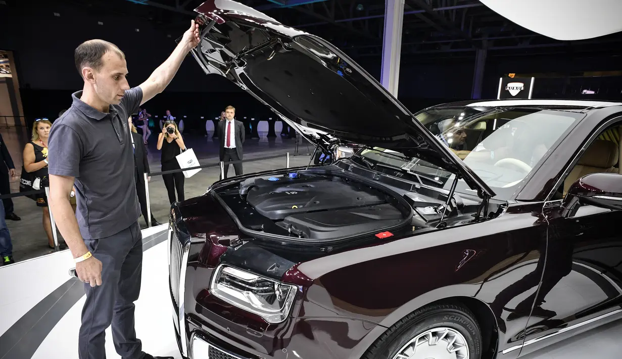 Pengunjung melihat bagian mesin mobil limosin Aurus Senat milik Presiden Rusia Vladimir Putin yang dipamerkan di Moscow International Motor Show di Moskow (29/8). (AFP Photo/Alexander Nemenov)
