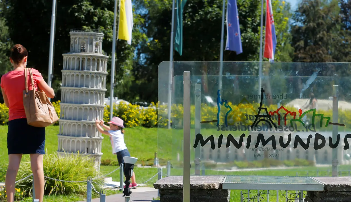 Seorang bocah berada di dekat miniatur Menara Pisa di Taman Minimundus, Klagenfurt, Austria, Senin (8/8). Taman Minimundus menampilkan aneka bangunan unik dari berbagai negara. (REUTERS/Heinz-Peter Bader)
