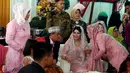 Kahiyang Ayu berbincang dengan Bobby Nasution saat prosesi pemberian marga dengan Manortor atau menari Tortor di rumah Pamannya Bobby Nasution di Medan, Selasa (21/11). (Liputan6.com/JohanTallo)